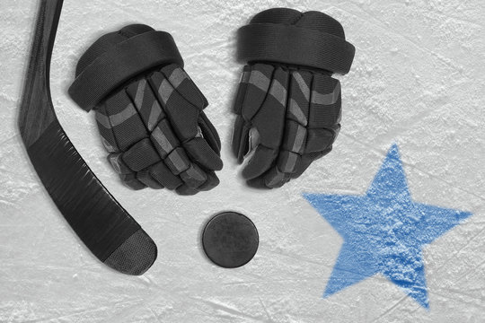 An image of a blue star on ice and hockey accessories