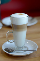 latte coffee in a transparent glass on a light background