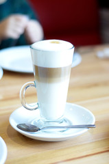 latte coffee in a transparent glass on a light background