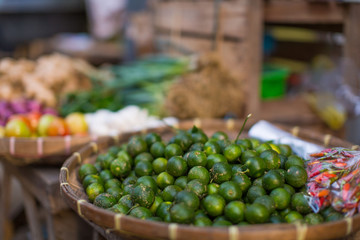 street stall vegetables business with calamondin lime chili and tomatoes in local market place of Philippines