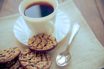 Coffee with biscuits on brown wooden background