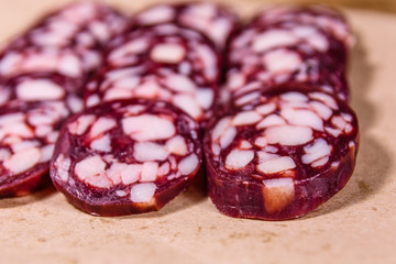 Sliced salami sausage on a brown wrapping paper