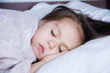 Obraz na płótnie Canvas little girls sleeping lying on bed. sleep schedule in domestic lifestyle. cute baby child
