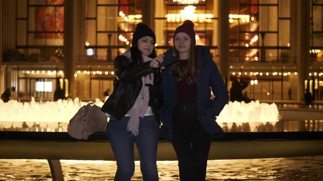 Two girls have an amazing night in New York while sitting at a fountain
