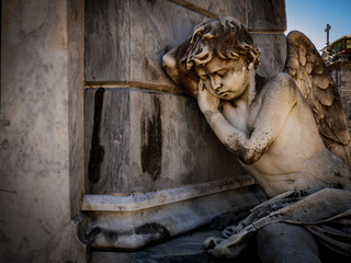 weathered angel rests on tomb