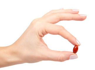 red vitamin capsule in blister with hand, medicine supplement