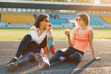 Healthy lifestyle and healthy food concept. Smiling fitness mother and teen daughter together...