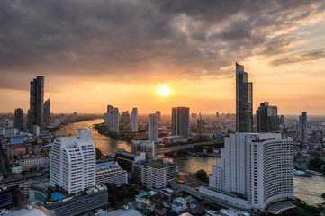 Obraz premium Cityscape of skyscraper with Chao Phraya river at sunset in Bangkok