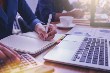 Woman accountant working using calculator for calculate financial report at the workplace.