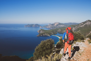 Traveler with backpack stands on the cliff