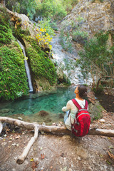 Traveler, woman admires waterfall
