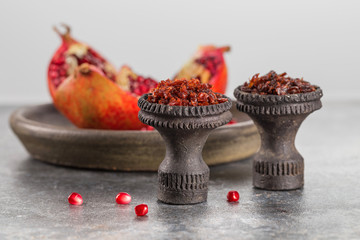 Different varieties of Shisha Smoking hookah. Black annealed ceramic bowl for hookah in the background of the open pomegranate.