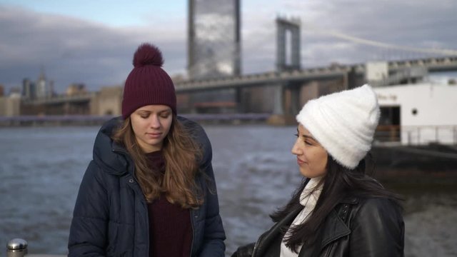 Two friends travel to New York for sightseeing at Brooklyn Bridge