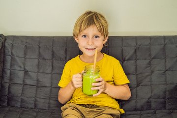 The boy is drinking Green tea latte with ice in mason jar. Homemade Iced Matcha Latte Tea with Milk...
