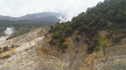 Fototapeta na wymiar plateau with volcanic activity, geothermal activity and geysers. aerial view volcanic landscape Dieng Plateau, Indonesia. Famous tourist destination of Sikidang Crater it still generates thick sulfur