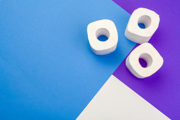 Rolls of toilet paper on color background, top view