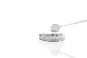 Model of plaster teeth with dental tools isolated in with background.