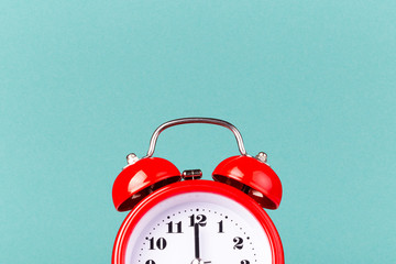 Half part of red alarm clock on blue background with copy space.