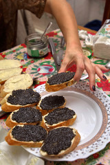 Cooking sandwiches with black caviar. Hand puts the finished sandwich on a plate, close-up