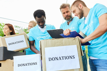 Freiwillige im Ehrenamt mit Spendenboxen