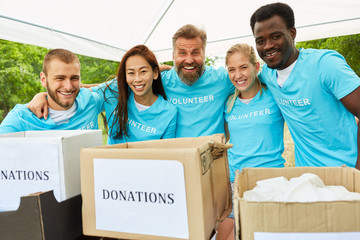 Freiwillige mit Spendenboxen freuen sich