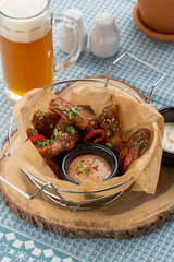 buffalo bbq chicken wings with cheese dip and glass of beer on the table