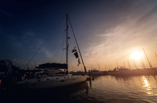 Beautiful view of marina and harbor with yachts and motorboats. Sunset at the ocean.