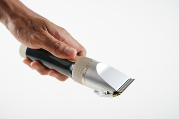 Asian hand in cropped holding shaving machine in white background. 