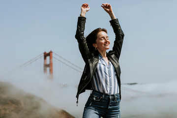 Happy woman posing for a photo at the Golden Gate Bridge, San Francisco - Powered by Adobe