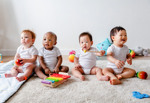 black and white babies playing together