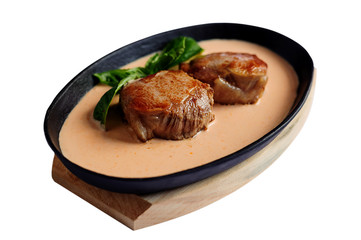 Juicy pork medallions in sauce on the iron pan