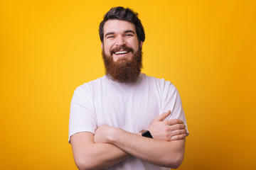 Portrait of smiling man with beard in white shirt with crossed arms