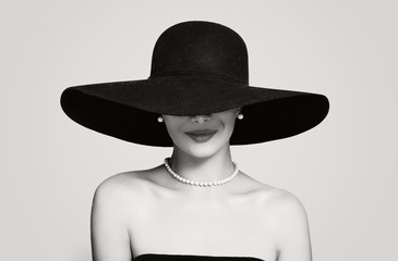 Black and white portrait of vintage woman in classic hat and pearls jewelry, retro styling girl - Powered by Adobe
