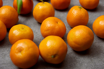 selective focus of organic tangerines on grey table