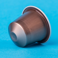 Brown coffee cup on a blue background. Modern conceptual art.