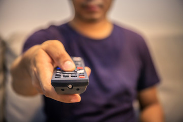 One man presses the TV remote 