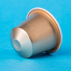 Golden coffee cup on a blue background. Modern conceptual art