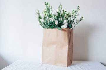 Bouquet of white eustom. Flowers close-up. Petals. White petals. Delicate. Wedding flowers. Flower delivery. Eco-package. Flowers in a paper bag. Eco-packaging. Flowers in the box.