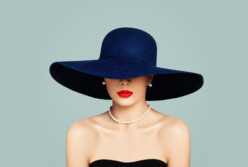 Elegant woman fashion model with red lips makeup wearing classic hat and white pearls, portrait
