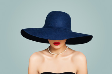 Fototapeta na wymiar Stylish woman with red lips makeup wearing classic hat and white pearls, fashion portrait