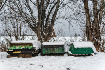 Naklejka premium A boats covered with snow on the coast