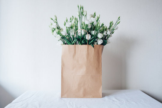 Bouquet of white eustom. Flowers close-up. Petals. White petals. Delicate. Wedding flowers. Flower delivery. Eco-package. Flowers in a paper bag. Eco-packaging. Flowers in the box.
