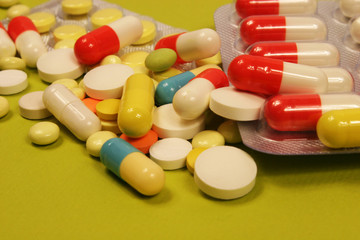 Pharmaceutical medicament, cure in container for health and heart on green background.