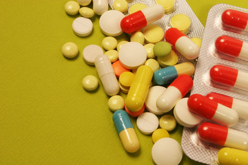 Pharmaceutical medicament, cure in container for health and heart on green background.