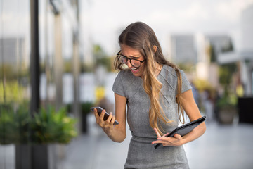 Business person freaking out, rushed, overloaded, in a work crisis receives bad news on cellphone