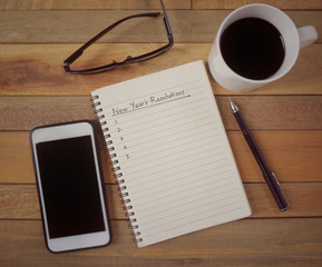 New year resolutions concept - ‘New Year’s Resolutions written on a notepad. Vintage styled background.