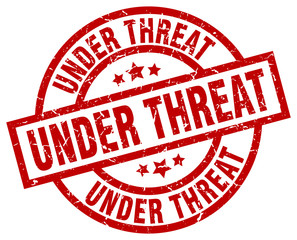 under threat round red grunge stamp