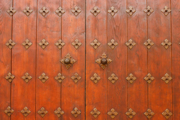 Puerta de madera con adornos metálicos estilo antiguo