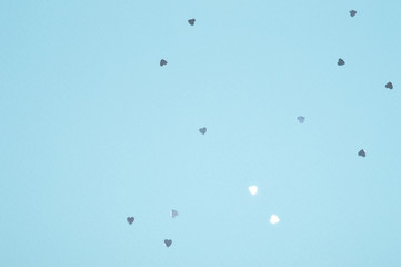 Silver glitter hearts on blue background in vintage colors