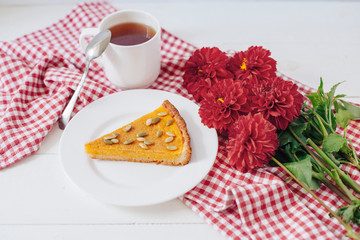 Pumkin pie with seeds on white plate with spoon and napkin